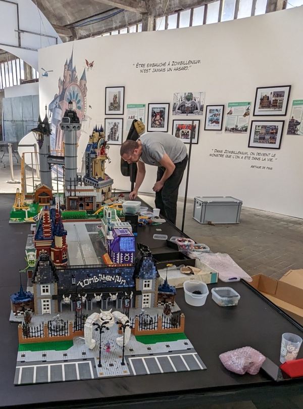 Stéphane Dély installant le parc en briques Lego de l'exposition Zombillénium