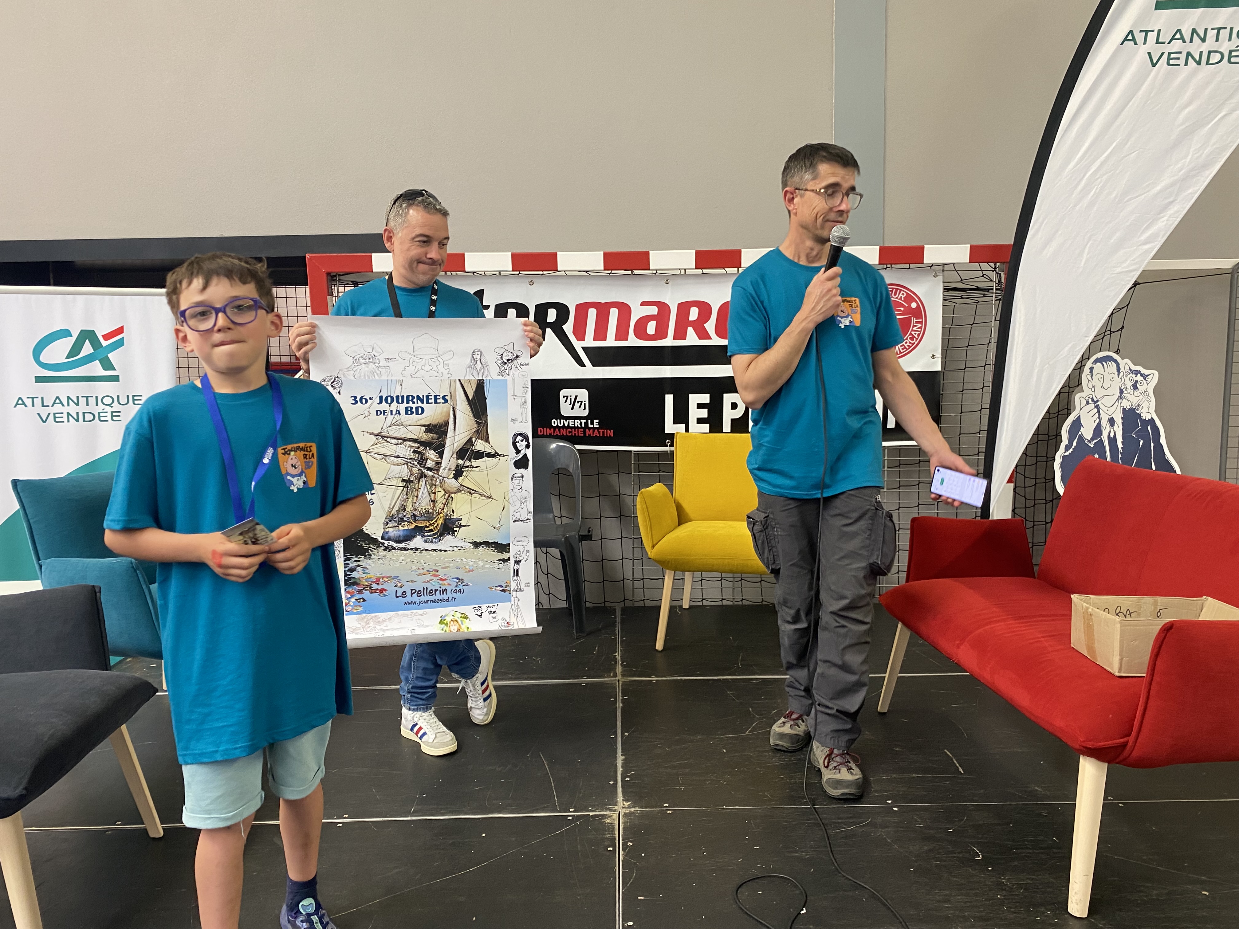 Une main innocente effectue le tirage de l'affiche dédicacée par les auteurs et autrices 