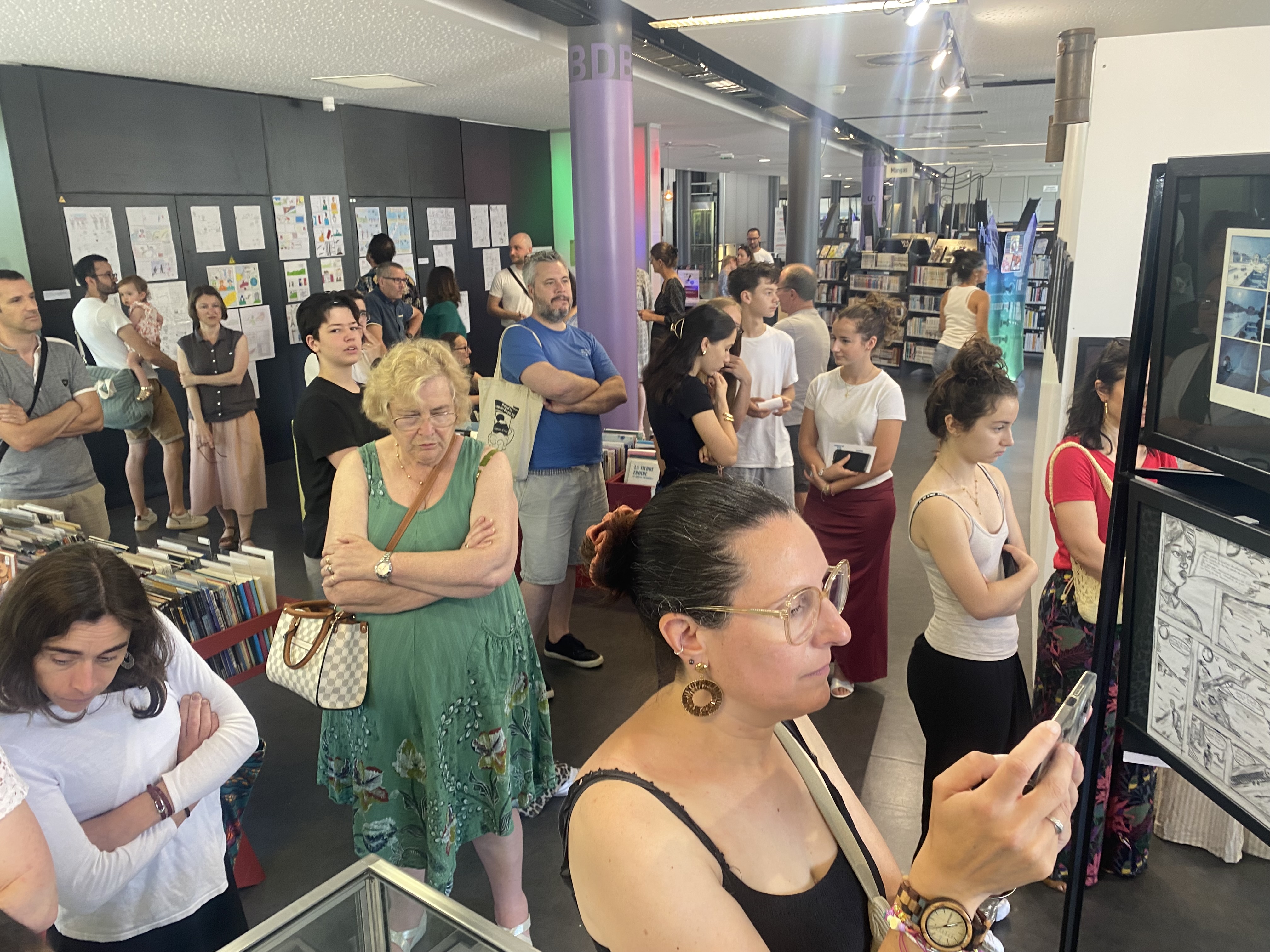 Le public devant les planches de Dominique Bertail et des élèves à la médiathèque de Montargis